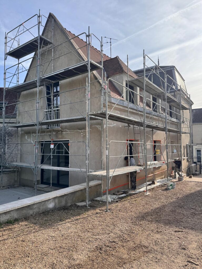 Maison en rénovation avec échafaudages.